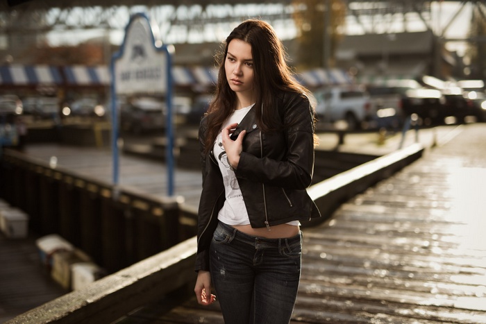 Woman in leather jacket and jeans on a pier