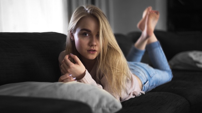 Woman with blonde hair lying on a couch