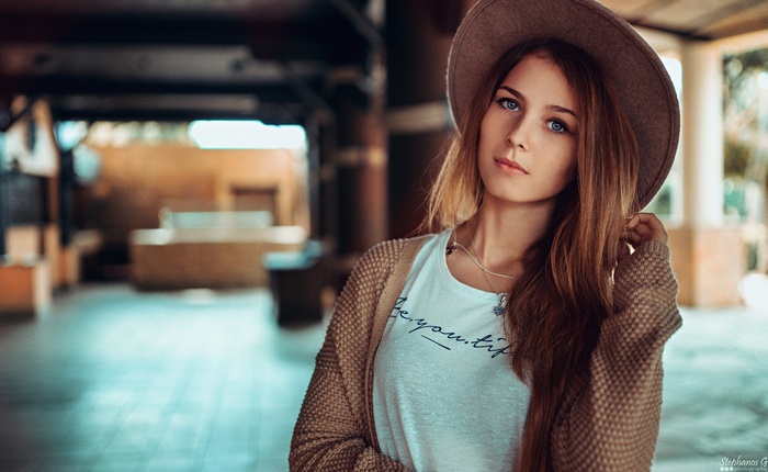 Woman with blue eyes wearing a hat and cardigan