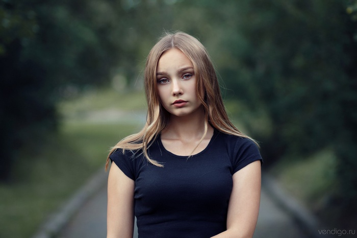 Young woman with blonde hair in a black t-shirt outdoors