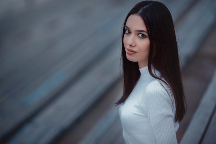 Woman in white turtleneck looking at viewer