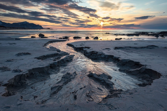 Beach stream at sunset with mountains