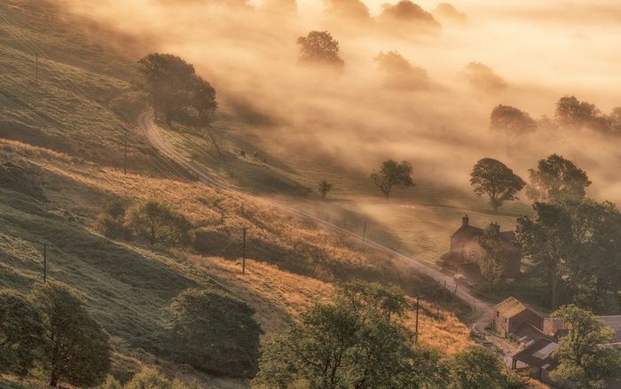 Misty valley with a winding road and houses