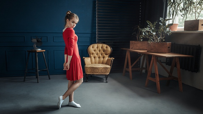 Woman in red dress standing in a room