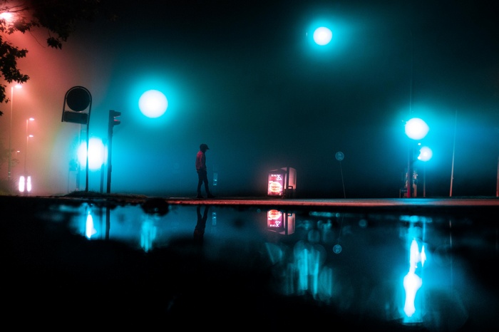 Person walking at night with neon lights and reflections
