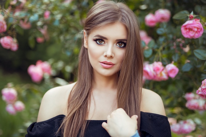 Woman with brown eyes and smoky eyes in front of roses