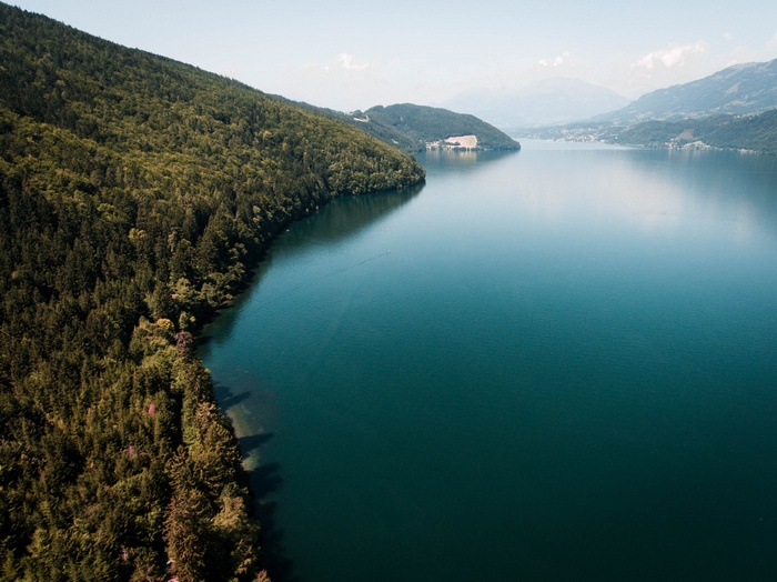 Forest-covered mountains meet a tranquil lake