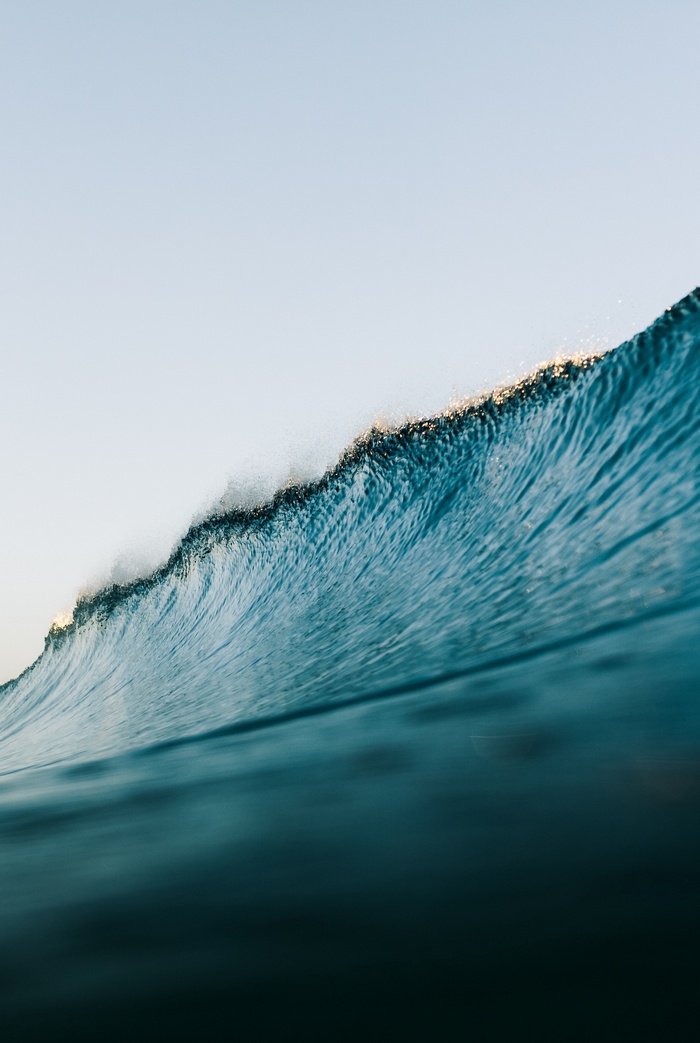 Ocean wave cresting with sunlight