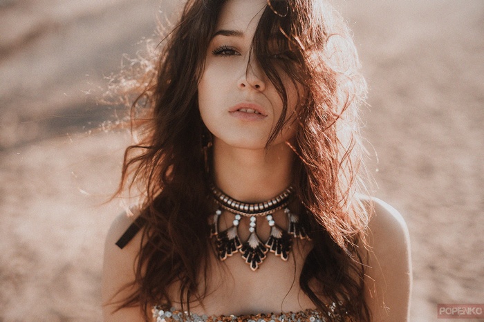 Woman with dark hair and a large necklace