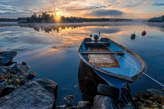 Boat on a misty lake at sunrise