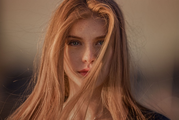 Portrait of a young woman with freckles and blonde hair