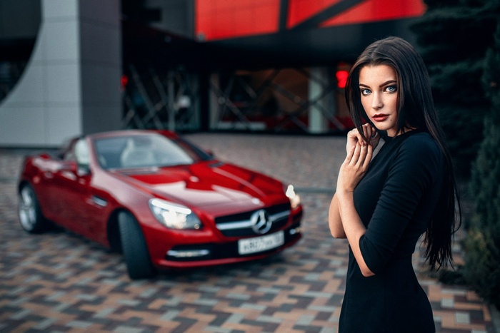 Woman in black dress with red Mercedes-Benz