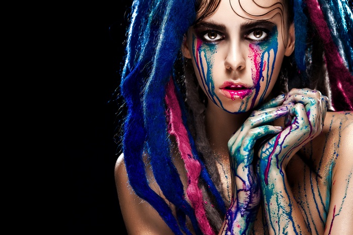 Woman with colorful paint and blue dreadlocks