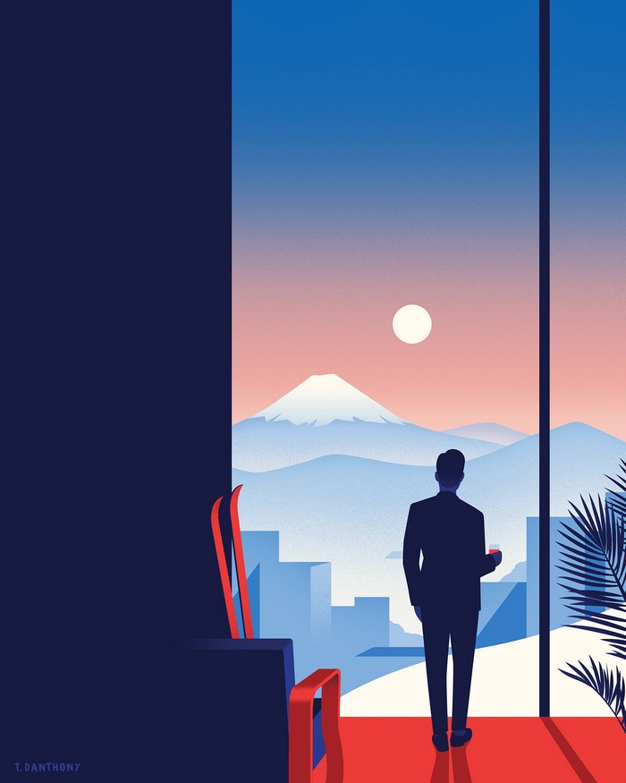 Man in suit looking at snowy mountains from window