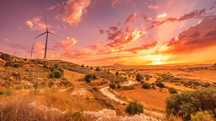 Wind turbines on a hill at sunset
