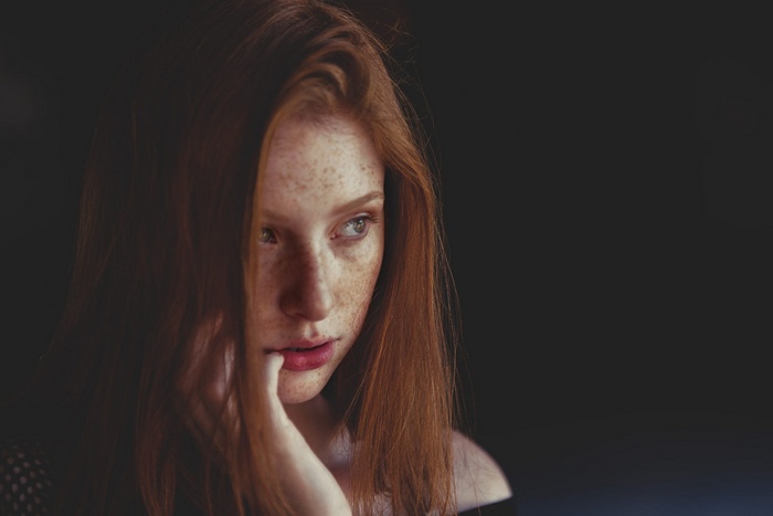 Redhead woman with freckles looking away