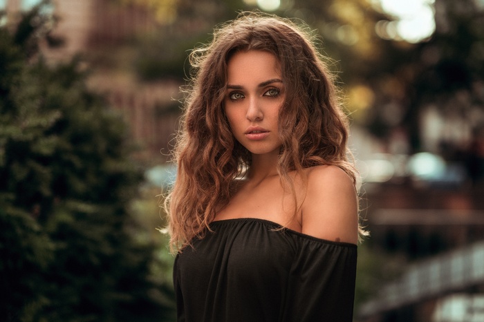 Portrait of a woman with curly brown hair and green eyes