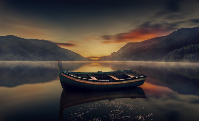 Boat on a misty lake at sunrise