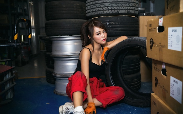 Woman in red overalls with tires and boxes