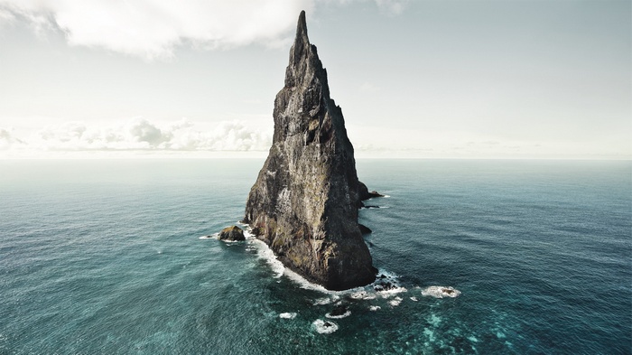 Jagged rock formation in the sea under a cloudy sky