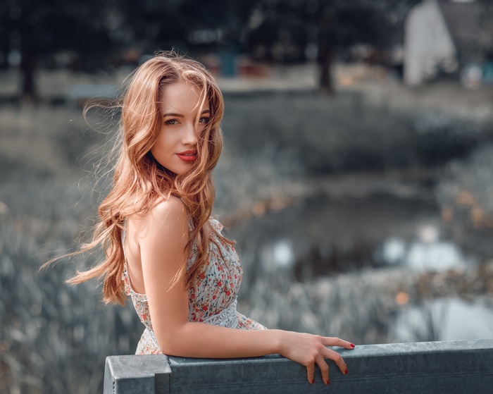 Portrait of a woman with red lipstick and red nails outdoors