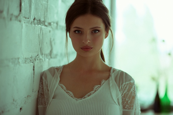 Portrait of a woman leaning against a brick wall