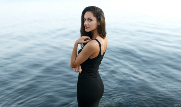 Woman in black dress by the water