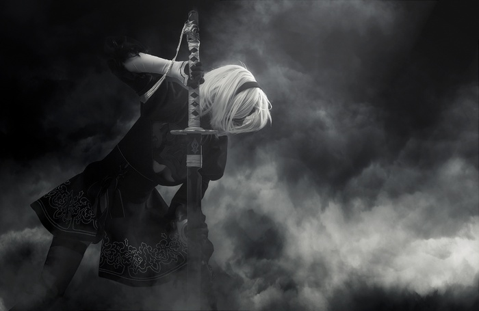 2B from NieR: Automata holding a sword in smoke