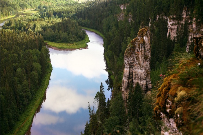 River winding through a forest with rocky cliffs
