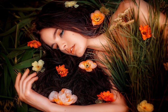Woman lying in grass with flowers