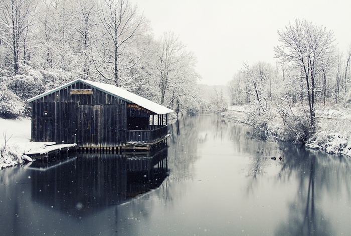 Wooden boathouse on a river in winter