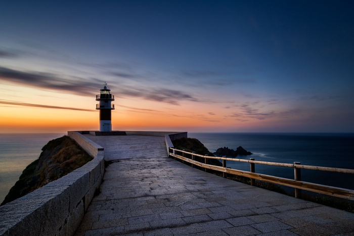 Lighthouse on a cliff at sunset
