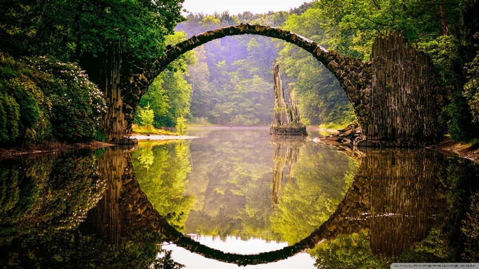 Rakotzbrücke bridge reflected in water surrounded by forest