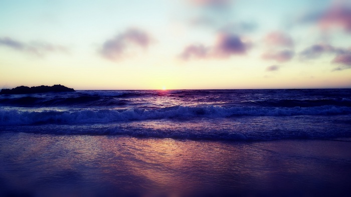 Ocean waves at sunset with clouds