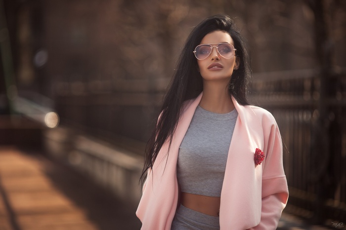 Woman with sunglasses and pink jacket outdoors