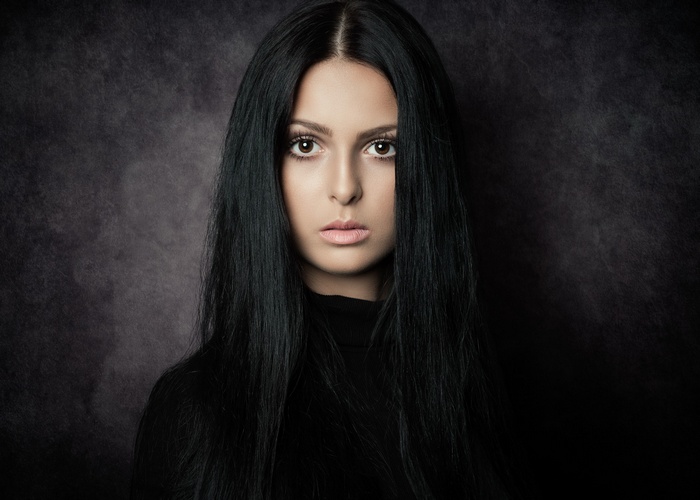 Woman with long black hair in a black turtleneck