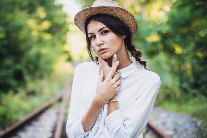 Woman in straw hat on railway tracks