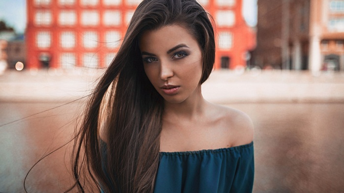 Woman with long brown hair and bare shoulders