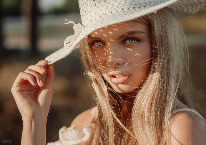 Woman in a straw hat with sunlight on her face