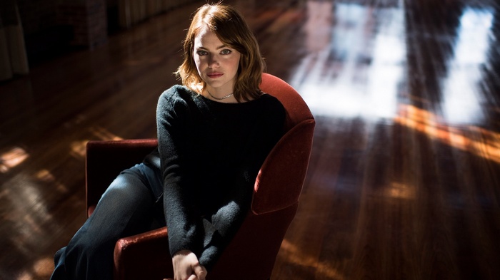 Emma Stone sitting in a chair