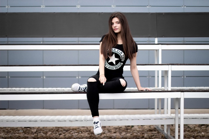 black clothing, sitting, T-shirt, pants, sneakers, women, torn jeans