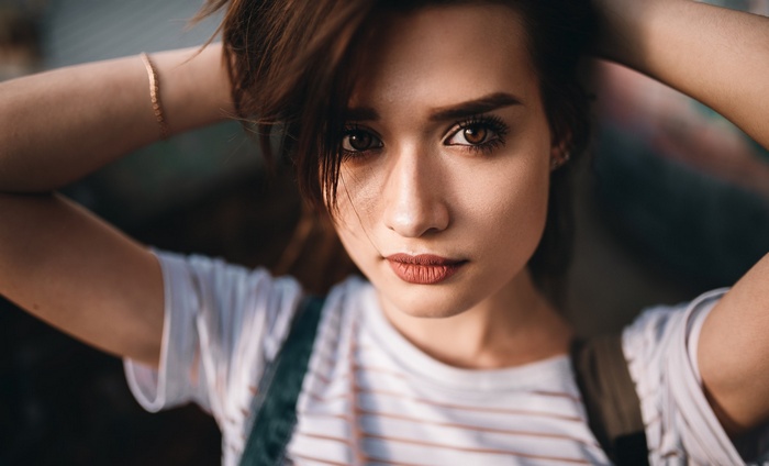 Woman with hands in hair, close-up portrait