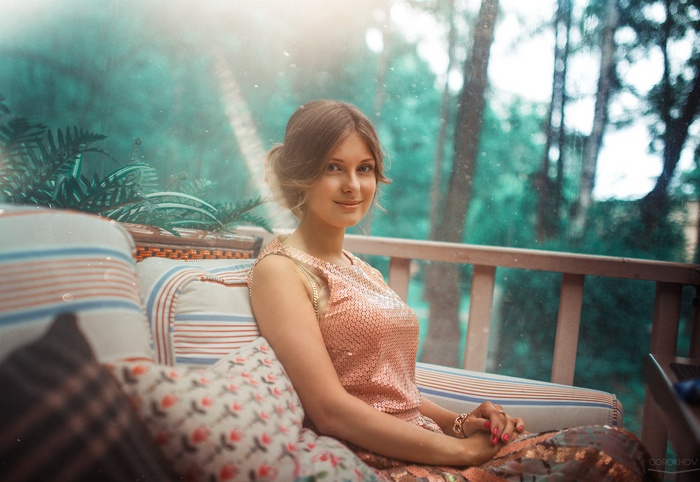 Woman in sequined dress sitting on a couch outdoors