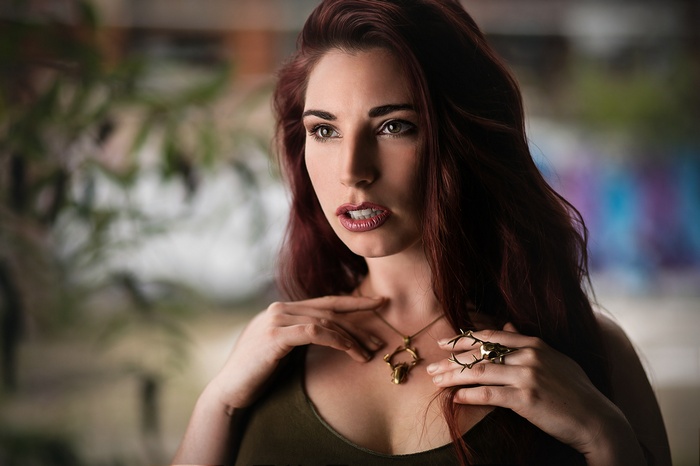 Woman with red hair wearing a necklace and ring