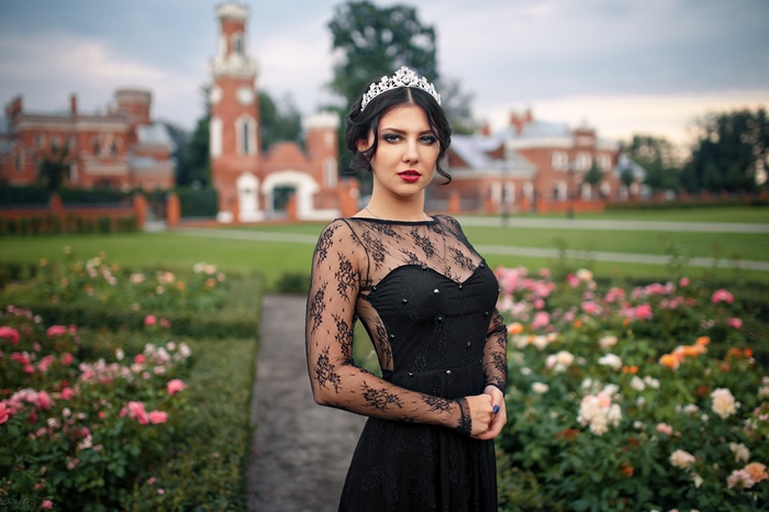 Woman in black lace dress and tiara in garden
