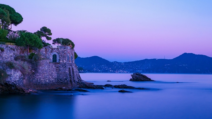 Stone fortress on a cliff overlooking the sea at dusk