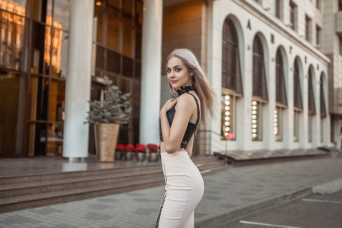 Woman in a black and white dress standing outside a building