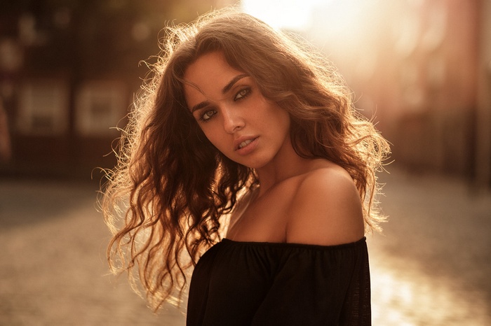 Woman with curly hair in sunlight