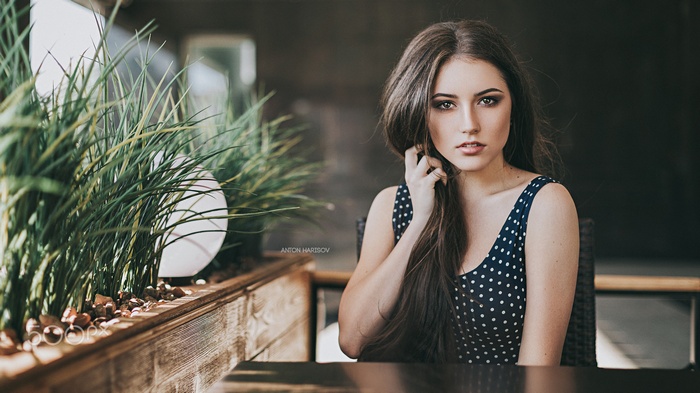 Woman with long brown hair in a polka dot dress