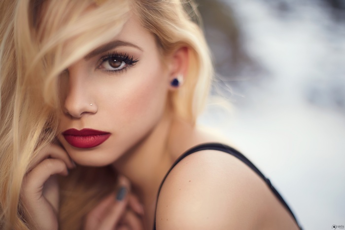 Woman with blonde hair, red lipstick, and nose piercing